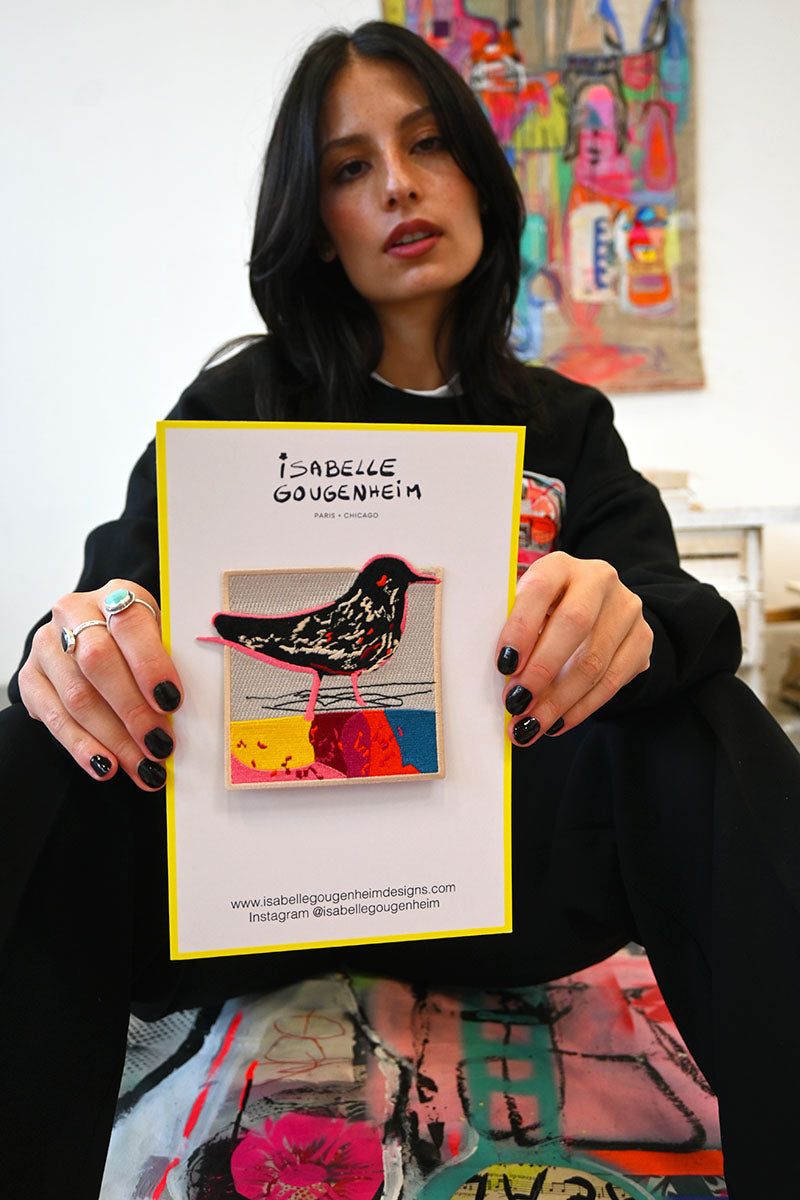 Person holding a card with artwork and branding