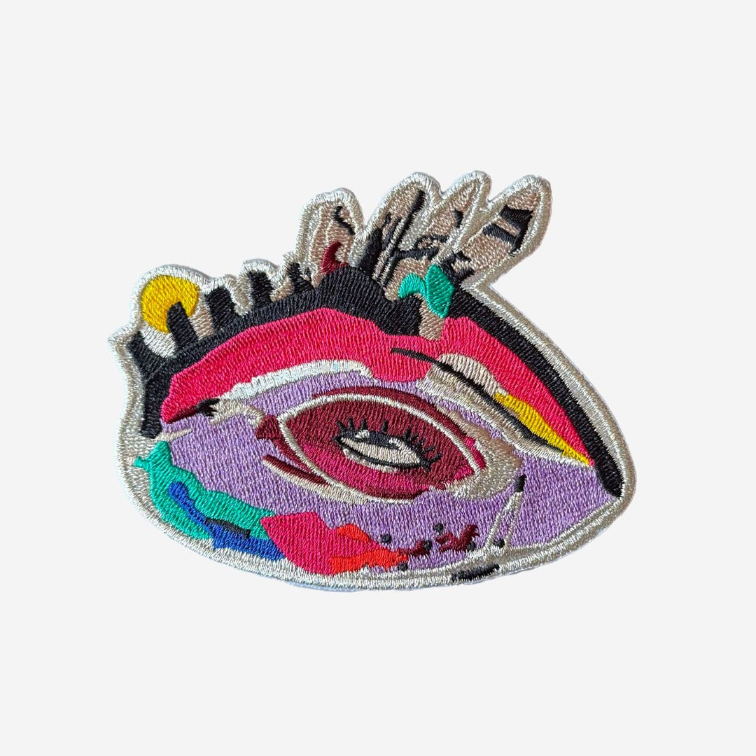 Colorful embroidered patch with an eye design on a white background