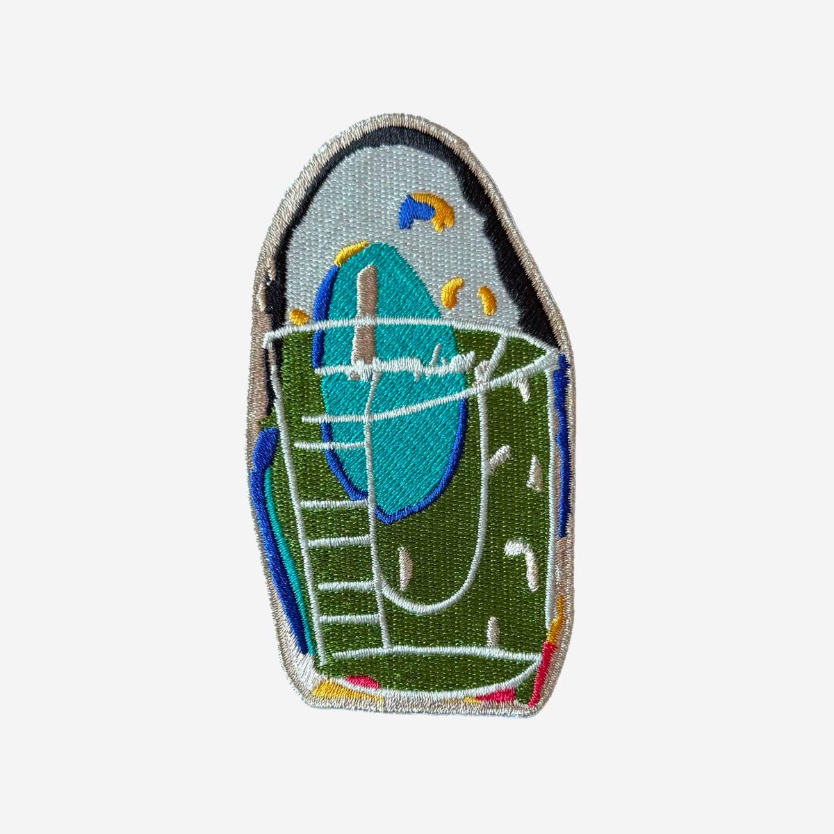 Embroidered patch of a bird in a cage on a white background