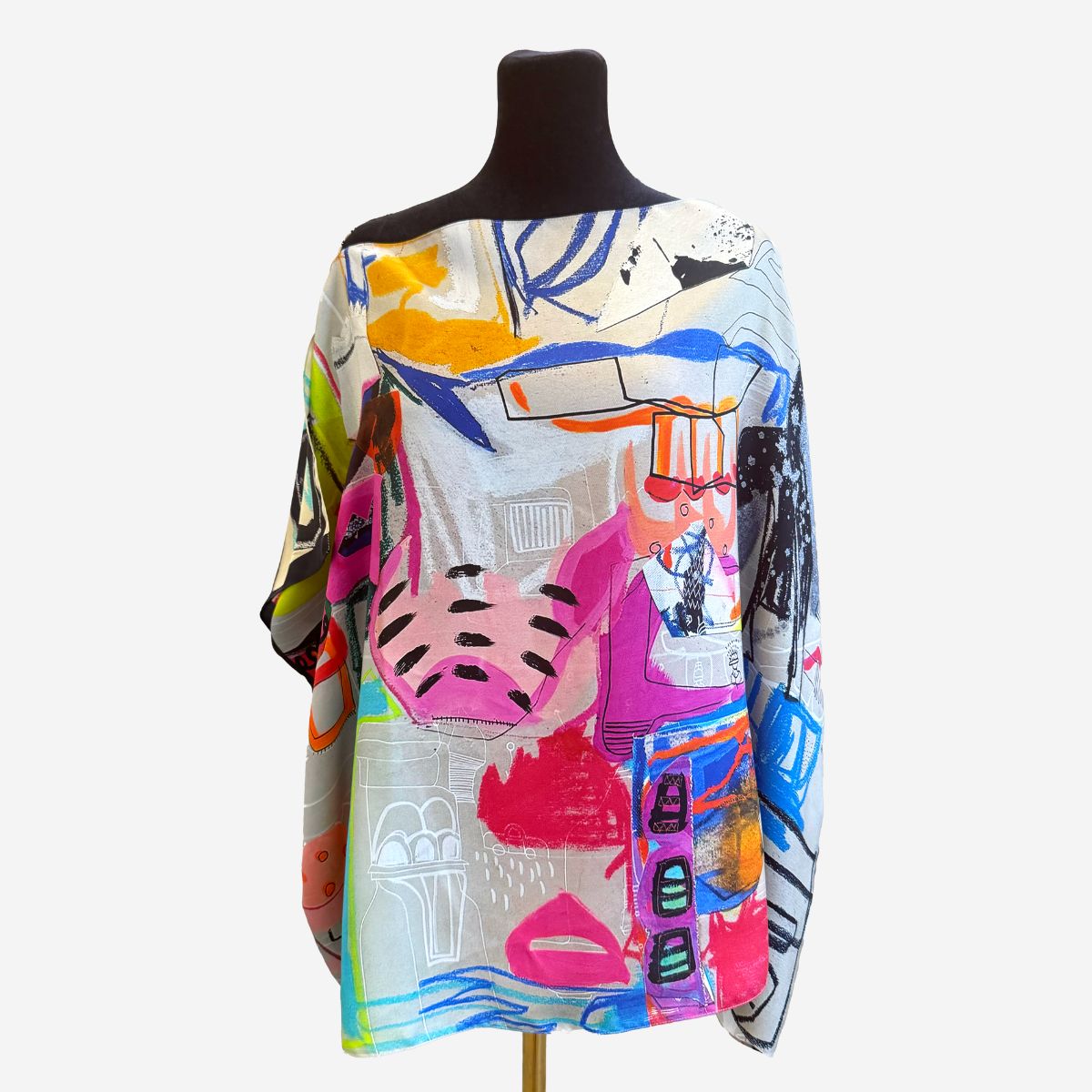 Colorful abstract patterned scarf on a mannequin against a white background