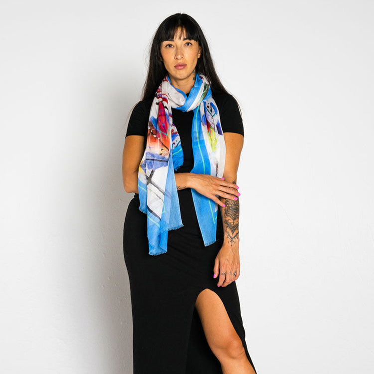 Woman wearing a colorful scarf and black outfit on a white background