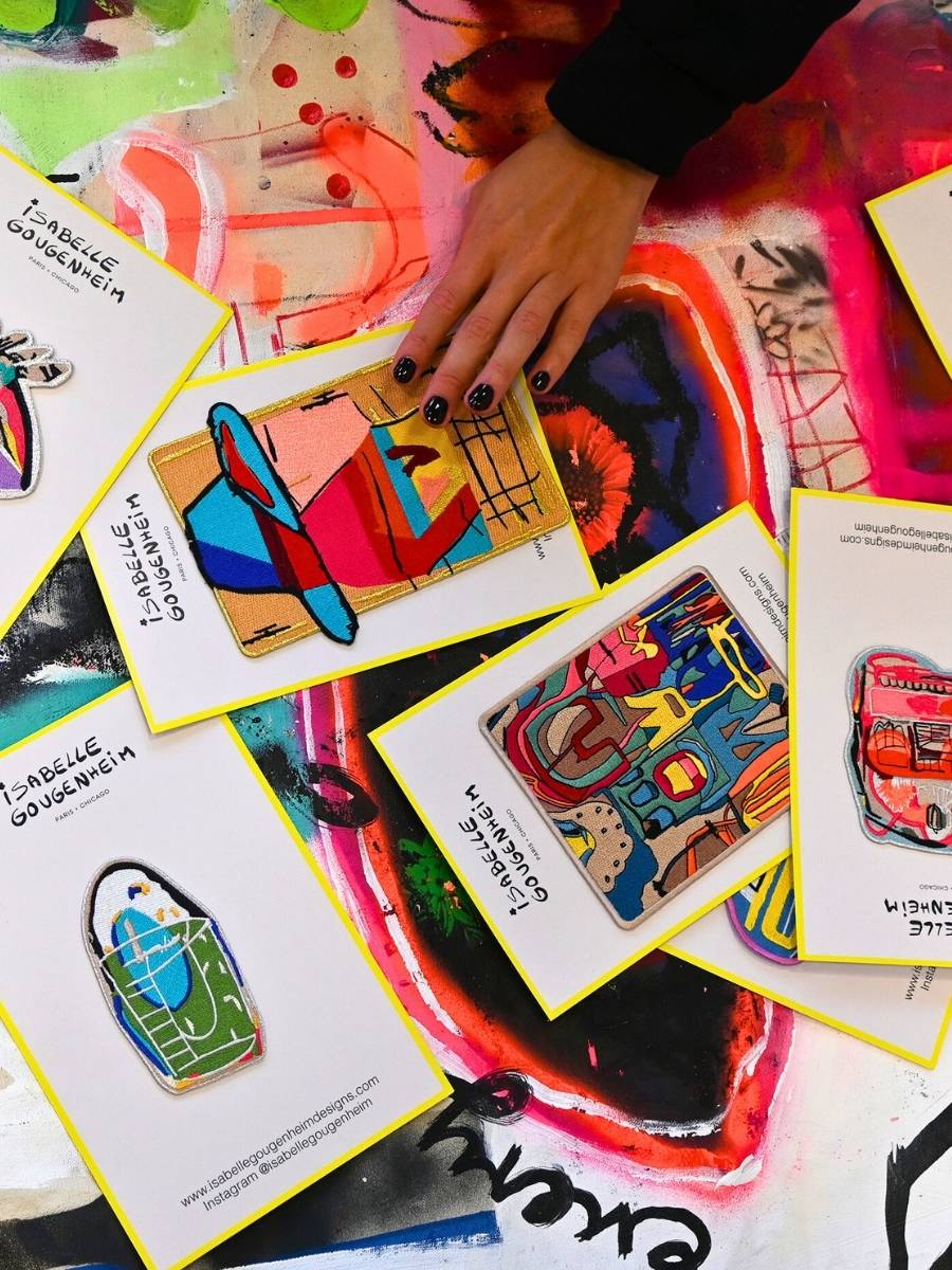 Colorful patches with a hand reaching towards one of them on a textured surface.