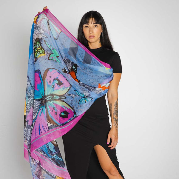 Woman holding a colorful butterfly-patterned scarf against a white background
